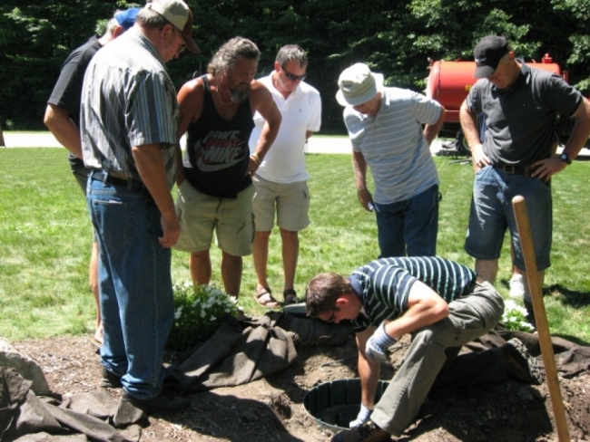 A team of workers digging out and inspecting a septic system